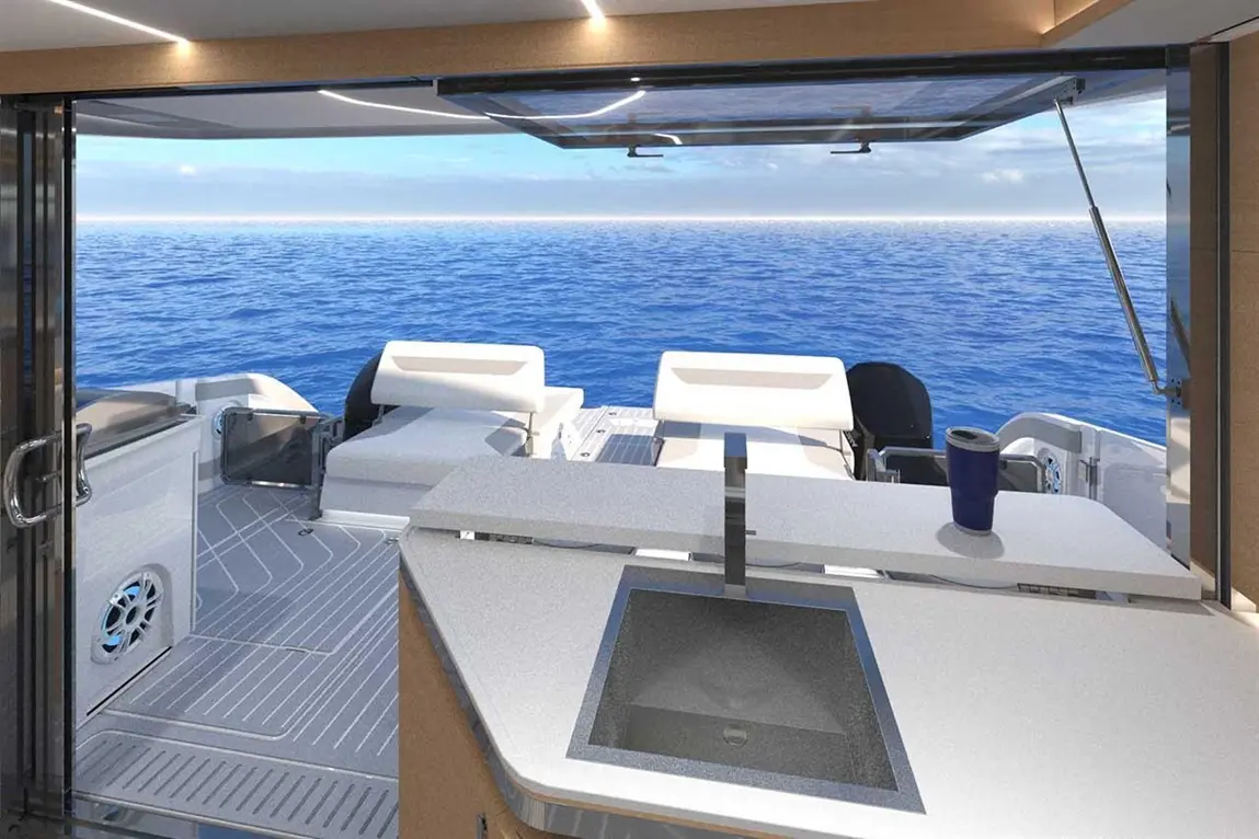Modern outdoor kitchen on a yacht, featuring a sleek countertop and ocean view, with white seating and a blue cup.
